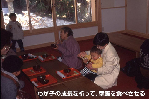 わが子の成長を祈って、奉飯を食べさせる