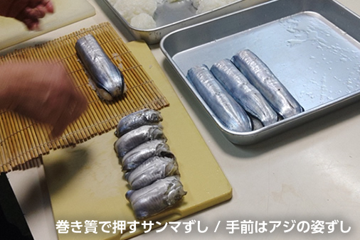 巻き簀で押すサンマずし/手前はアジの姿ずし