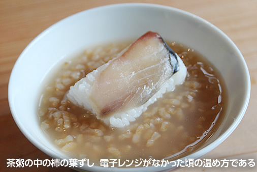 茶粥の中の柿の葉ずし。電子レンジがなかった頃の温め方である
